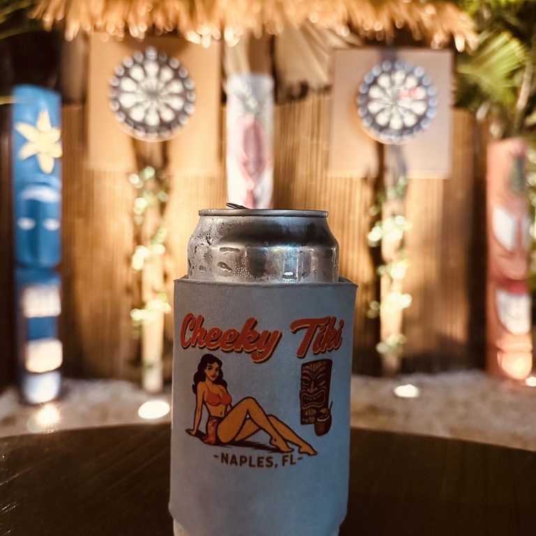 A cold can in a Cheeky Tiki koozie in front of the dartboards