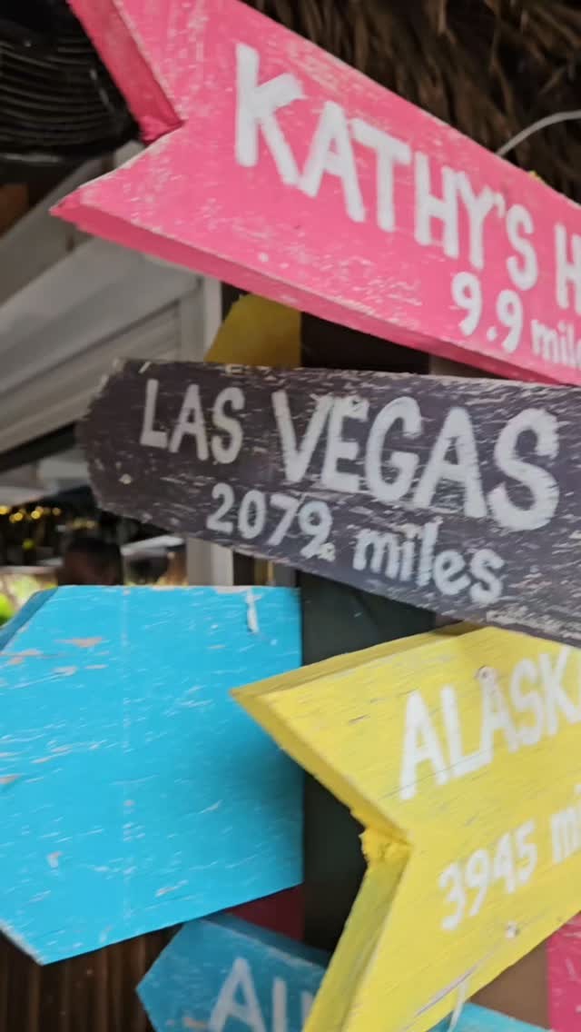 Hand-painted mile-marker signs pointing to Kathy’s House and Las Vegas
